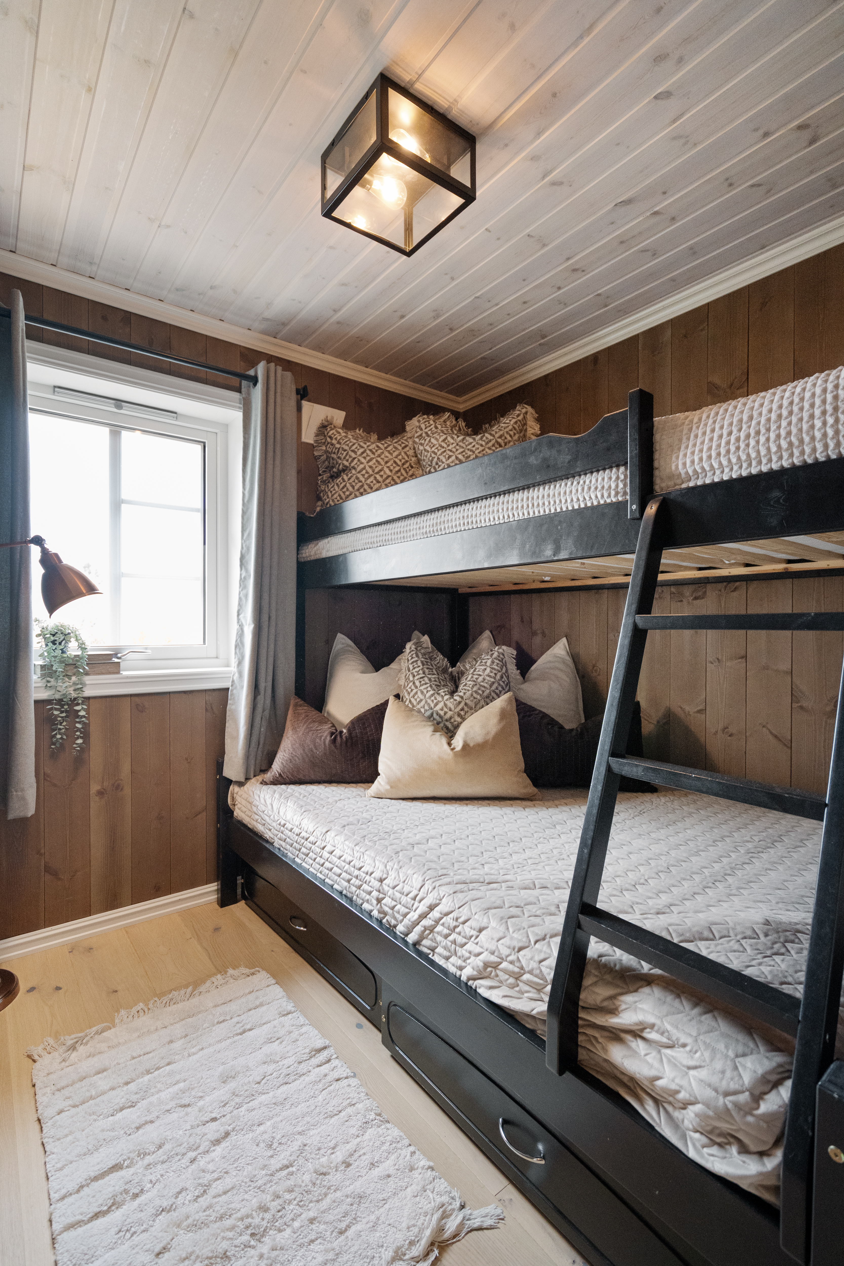 Smart innredet soverom med køyeseng og oppbevaringsplass under.