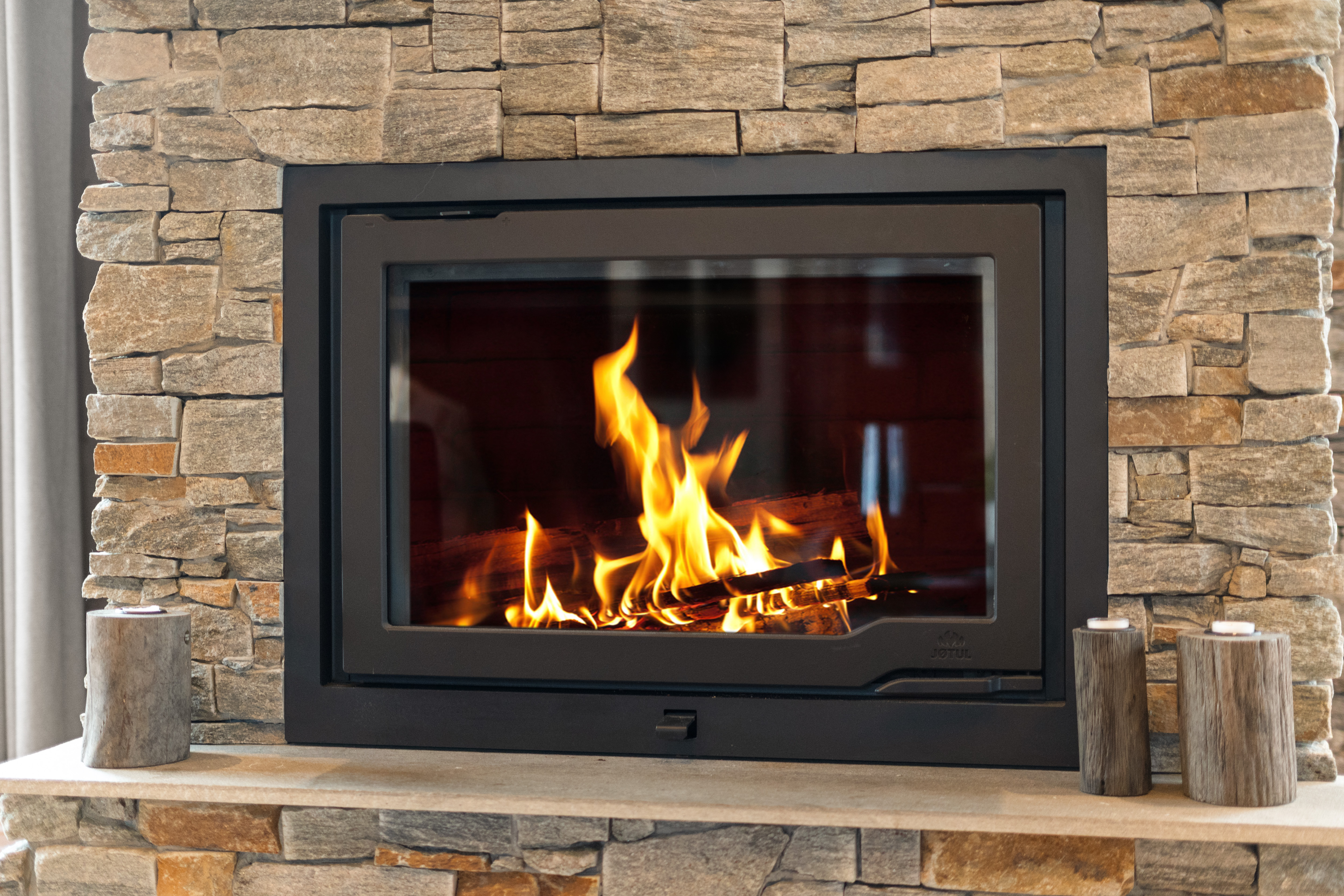 Moderne peis med innramming i stein – perfekt for koselige kvelder.