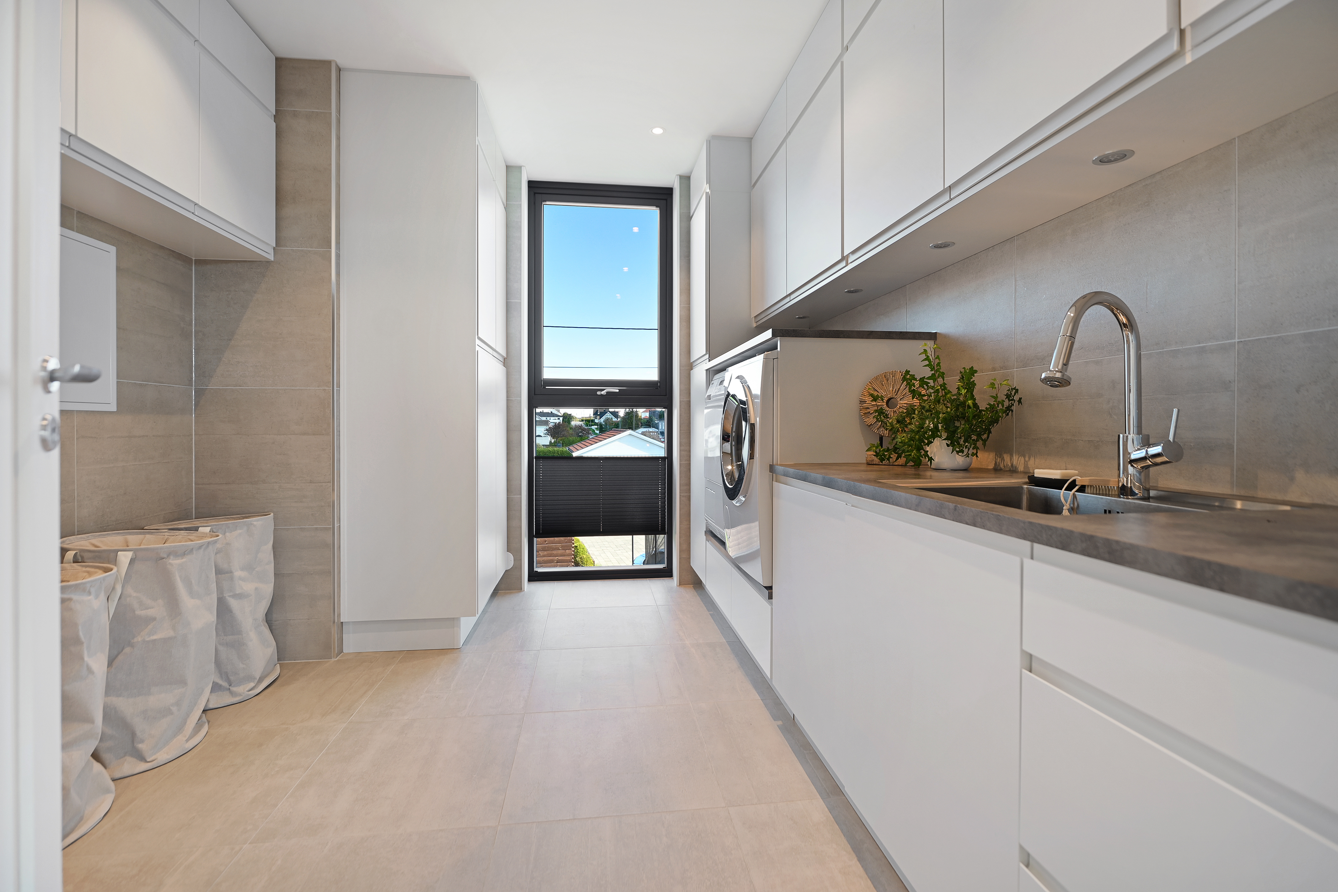 Romslig vaskerom med praktisk innredning og plass for tørkestativ.