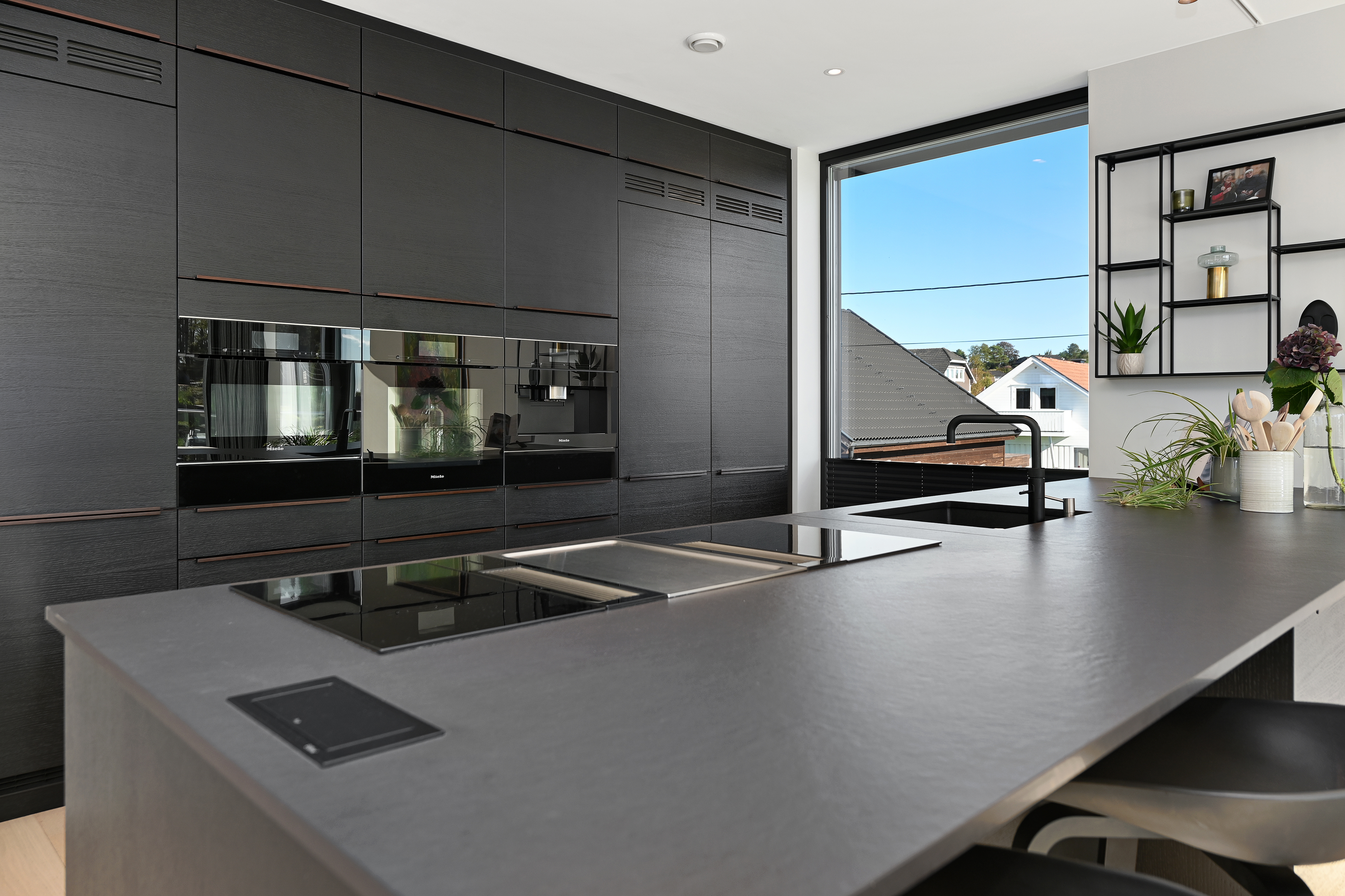 Godt utstyrt kjøkken fra Strai. Benkeplater i stein, Bora koketopp og Quooker kjøkkenkran.