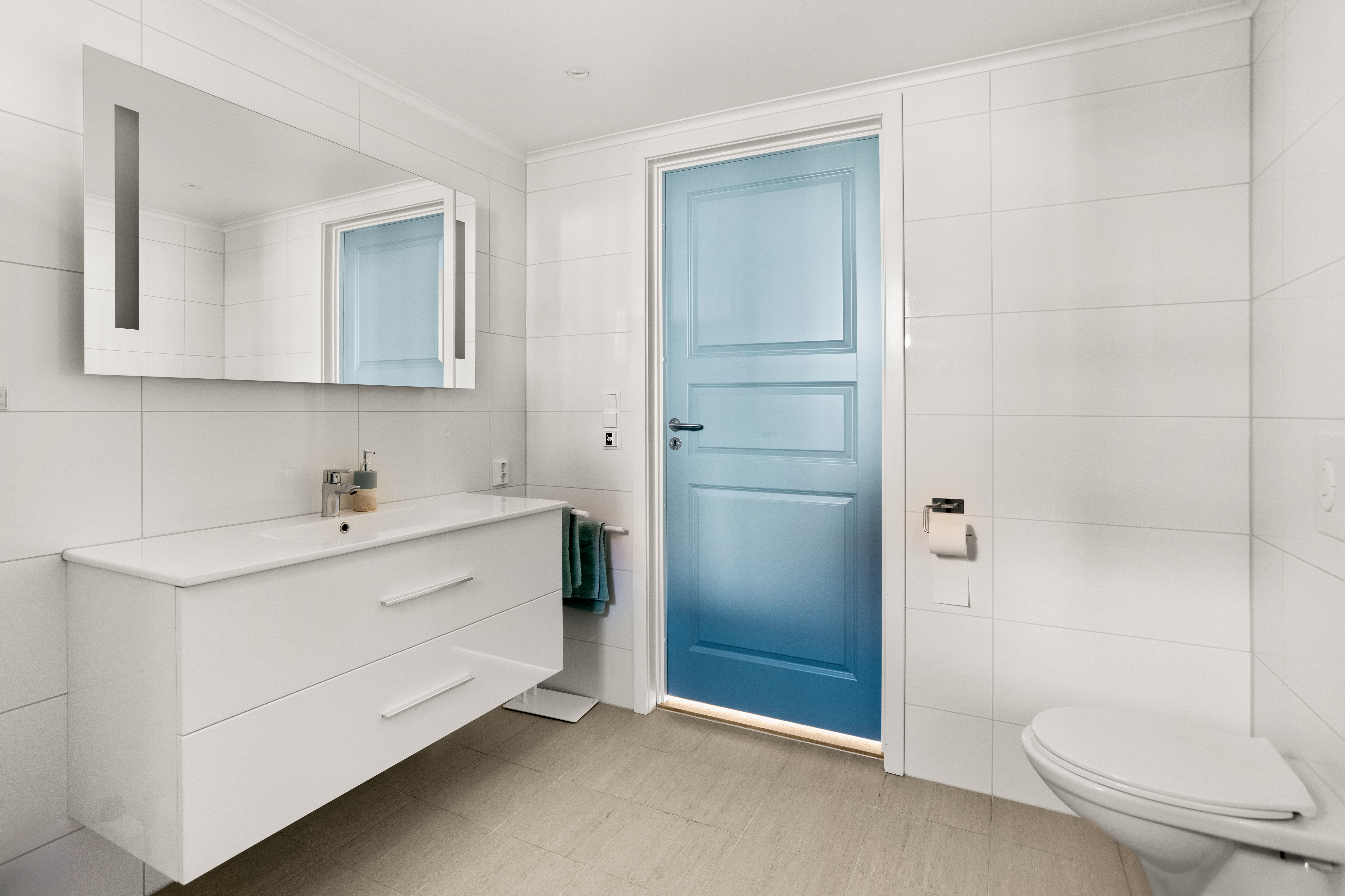 Boligen inneholder to bad, begge med gulv og vegger belagt med fliser som gir et helhetlig uttrykk.