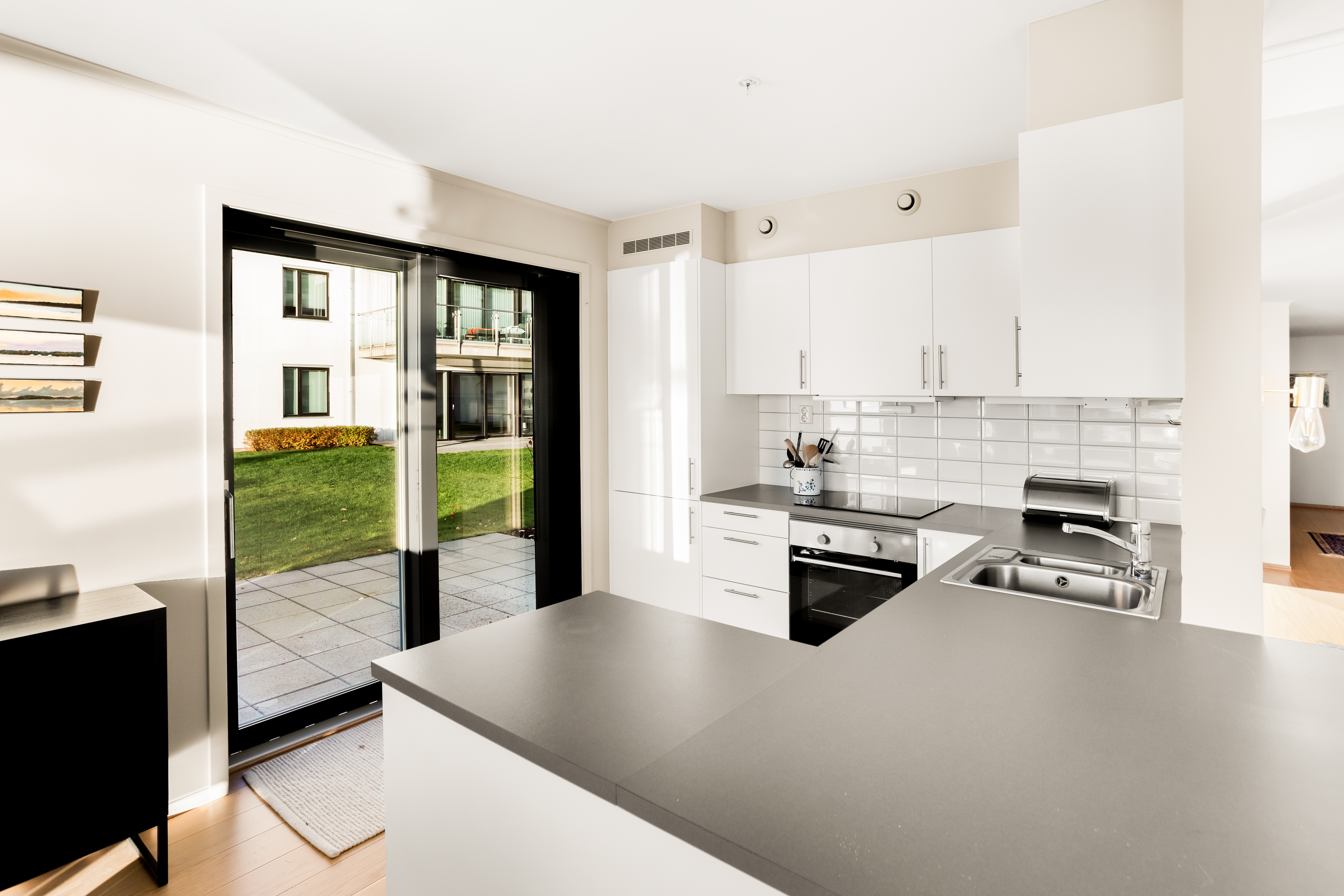 Plattingen utenfor kjøkkendøra er en praktisk og fin sitteplass, med strømuttak og fin plass til grill. Denne er ofte i le for vestavind med kveldssol om sommeren.