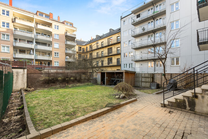 Bakgården er opparbeidet med blant annet asfalterte veier, plenarealer og andre forskjellige beplantninger.