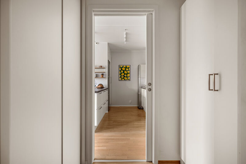 Mellom entréen og kjøkkenet er det en praktisk bod innredet med skyvedørsgarderobe og garderobeskap.