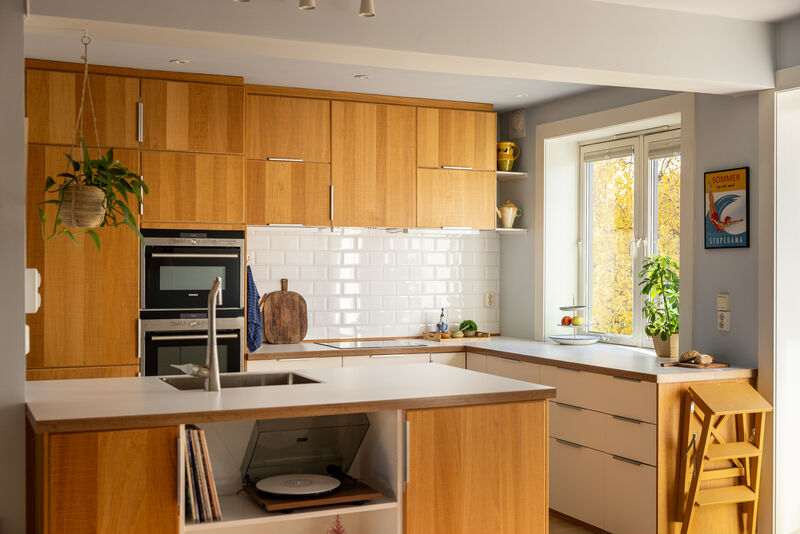 Det fine kjøkkenet er fra 2013 og har et tidløst og moderne uttrykk med glatte fronter (fin kombinasjon og flott eik på overskap og kjøkkenøy og hvite underskap) og lys laminat benkeplate.